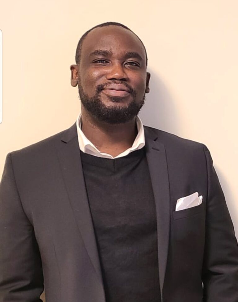 Portrait of Magloire Pierre-Louis in a charcoal blazer